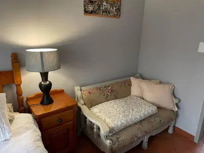 a room with a couch and a lamp next to a bed at Magalies House in Pretoria