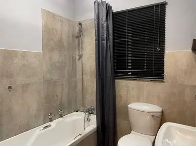 a bathroom with a toilet and a tub and a sink at Magalies House in Pretoria