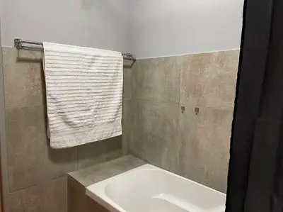 a bathroom with a shower with a sink and a towel at Magalies House in Pretoria