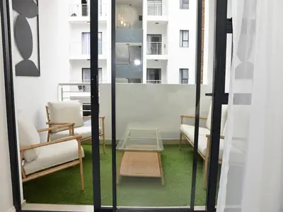 a room with two chairs and a table and a window at Elcaro Luxury Villas-Urban Taupe in Midrand