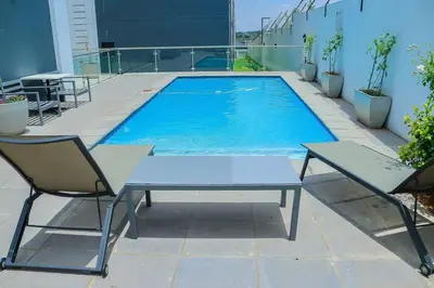 a swimming pool with two chairs and a table at Elcaro Luxury Villas-Urban Taupe in Midrand