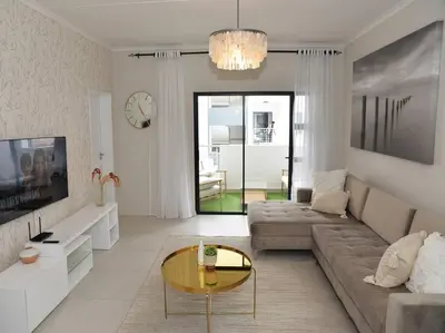 a living room with a couch and a table at Elcaro Luxury Villas-Urban Taupe in Midrand