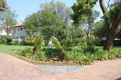 a garden with trees and plants on a sidewalk at Richtershuyz Luxury Accommodation in Pretoria