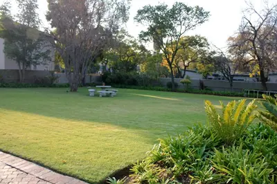 a lawn with a picnic table in a park at Richtershuyz Luxury Accommodation in Pretoria