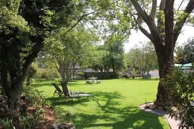 a park bench sitting in the middle of a yard at Richtershuyz Luxury Accommodation in Pretoria