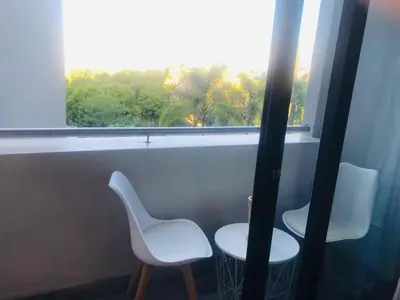 two white chairs sitting next to a window at Premier Lifestyle at The Regency in Pretoria