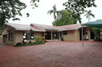 a house with a brick driveway in front of it at Tzaneen Guest House in Tzaneen