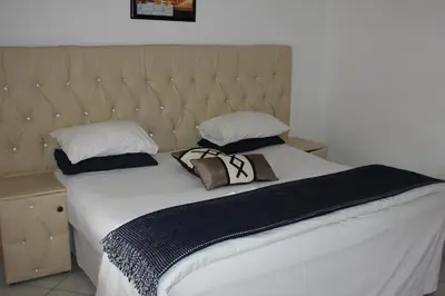 a bed with two pillows on top of it at Tzaneen Guest House in Tzaneen