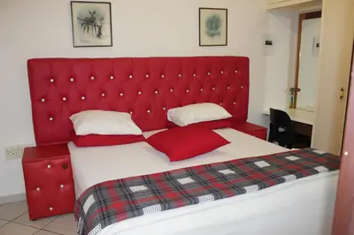 a red bed with a red headboard in a room at Tzaneen Guest House in Tzaneen