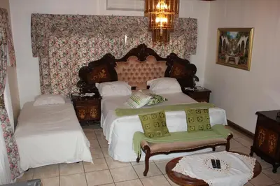 a bedroom with two beds and a chandelier at Tzaneen Guest House in Tzaneen