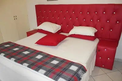 a red bed with red pillows and a red headboard at Tzaneen Guest House in Tzaneen