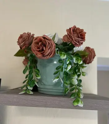 a green vase with flowers in it on a shelf at MorningMist Boutique Sun in Centurion