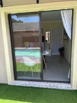 a sliding glass door leading to a patio with a pool at MorningMist Boutique Sun in Centurion