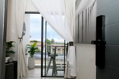a sliding glass door leading to a balcony with a table at Urbane- By LaSerene -Carlswald in Midrand