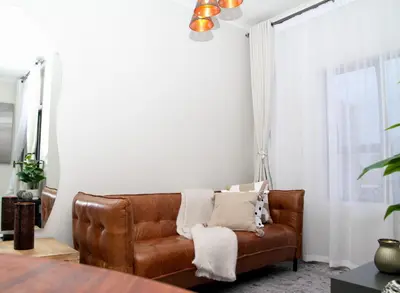 a living room with a brown leather couch at Urbane- By LaSerene -Carlswald in Midrand