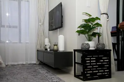 a living room with a tv and a table with a plant at Urbane- By LaSerene -Carlswald in Midrand