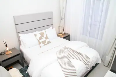 a bedroom with two white beds and a window at Urbane- By LaSerene -Carlswald in Midrand