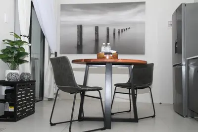 a table and chairs in a kitchen with a refrigerator at Urbane- By LaSerene -Carlswald in Midrand