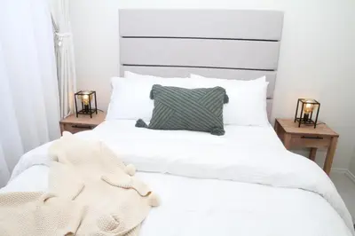 a bedroom with a white bed with a gray headboard at Sublime - By LaSerene - Carlswald in Midrand