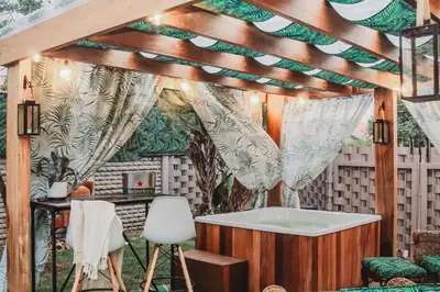 a bathroom with a bath tub and a table and chairs at Villa La'Vie in Witbank