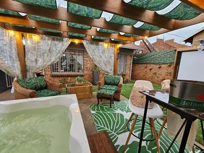 a room with a bath tub and a table and chairs at Villa La'Vie in Witbank