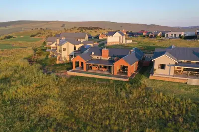 an aerial view of a house in a field at Highland gate Golf estate Mountain view 780 in Dullstroom