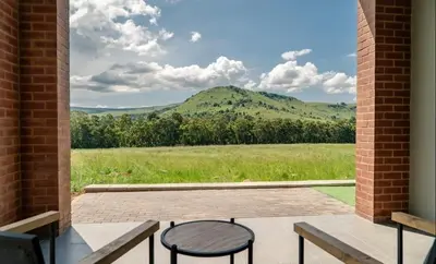 a patio with two chairs and a view of a mountain at Highland gate Golf estate Mountain view 780 in Dullstroom
