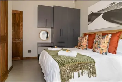 a bedroom with a large white bed and a mirror at Highland gate Golf estate Mountain view 780 in Dullstroom
