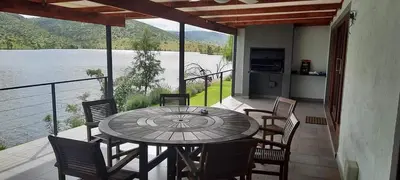 a patio with a table and chairs and a view of a lake at Fish Eagle Bay View, Warmbaths in Bela-Bela