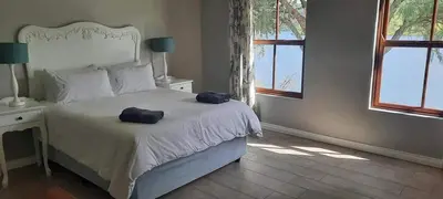 a bedroom with a white bed with two bags on it at Fish Eagle Bay View, Warmbaths in Bela-Bela