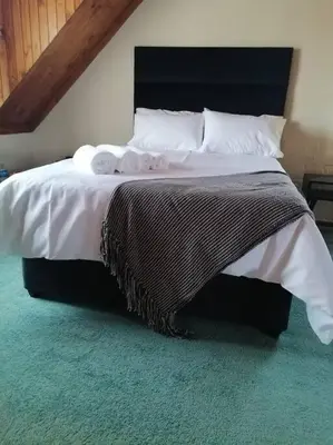 a bedroom with a bed with two towels on it at Traveller's dream in Graskop