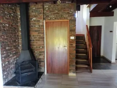 a brick wall with a door and a wood stove at Traveller's dream in Graskop
