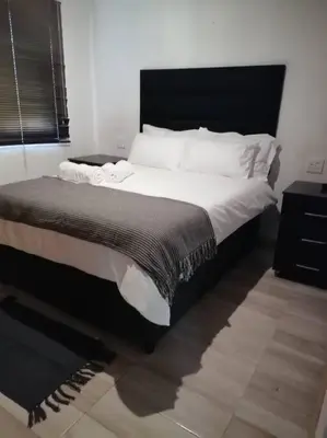 a bedroom with a large bed with a black headboard at Traveller's dream in Graskop