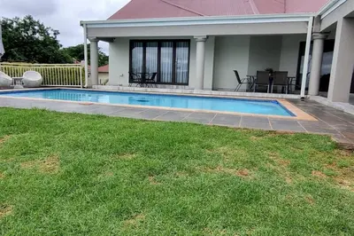 a swimming pool in a yard next to a house at The Acres Home in White River