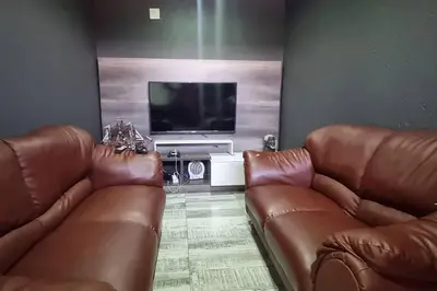 a living room with two brown leather couches and a flat screen tv at The Acres Home in White River