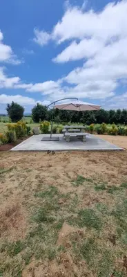 a picnic table with an umbrella in a field at The Acres Home in White River