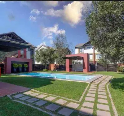 a house with a swimming pool in the yard at A Stunning Cozy Apartment in Midrand