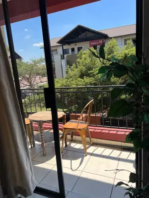 a chair and a table on a balcony at A Stunning Cozy Apartment in Midrand