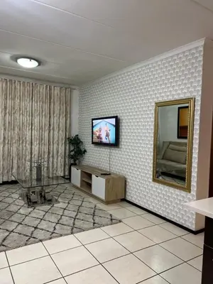 a living room with a television and a mirror at A Stunning Cozy Apartment in Midrand