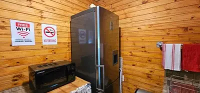a refrigerator and a stove in a room with wooden walls at Marepe Flora Mountain View in Kampersrus AH