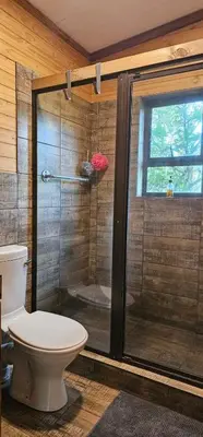 a bathroom with a glass shower with a toilet at Marepe Flora Mountain View in Kampersrus AH