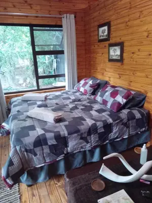 a bedroom with a bed in a log cabin at Marepe Flora Mountain View in Kampersrus AH
