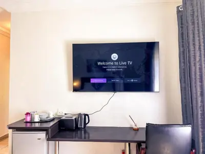 a television hanging on a wall above a desk at Bobisemo Luxury Pretoria East Apartment in Tierpoort