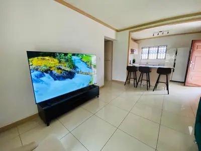 a living room with a large flat screen tv at Siena Sun Apartment 10 in Midrand