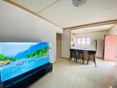 a living room with a large flat screen tv at Siena Sun Apartment 10 in Midrand