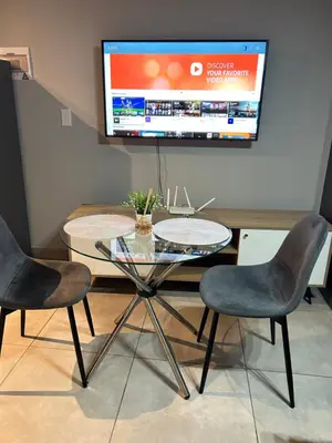 a table with two chairs and a tv on a wall at Circa Apartment 86 in Pretoria