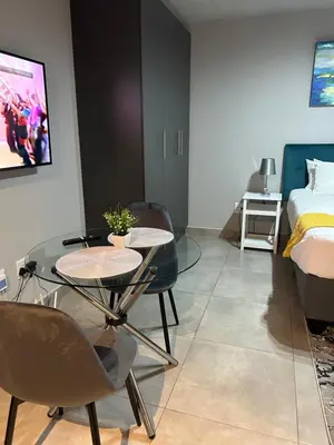 a room with a table and chairs and a bed at Circa Apartment 86 in Pretoria