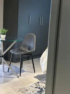 a chair sitting in front of a glass table at Circa Apartment 86 in Pretoria