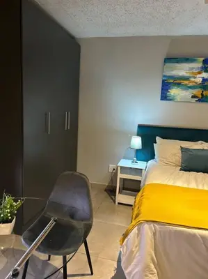 a bedroom with a bed and a chair in it at Circa Apartment 86 in Pretoria