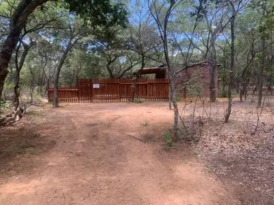 a wooden fence in the middle of a forest at Vlakkieskraal FarmStay - Bosvark Cabin in Bela-Bela